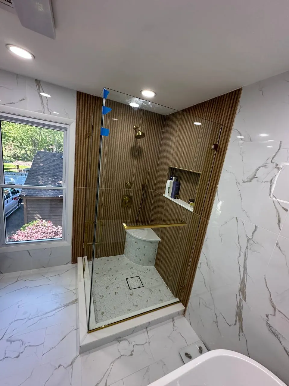 Clear tempered shower glass with brass hardware during MetroGlass Pro's Edison installation
