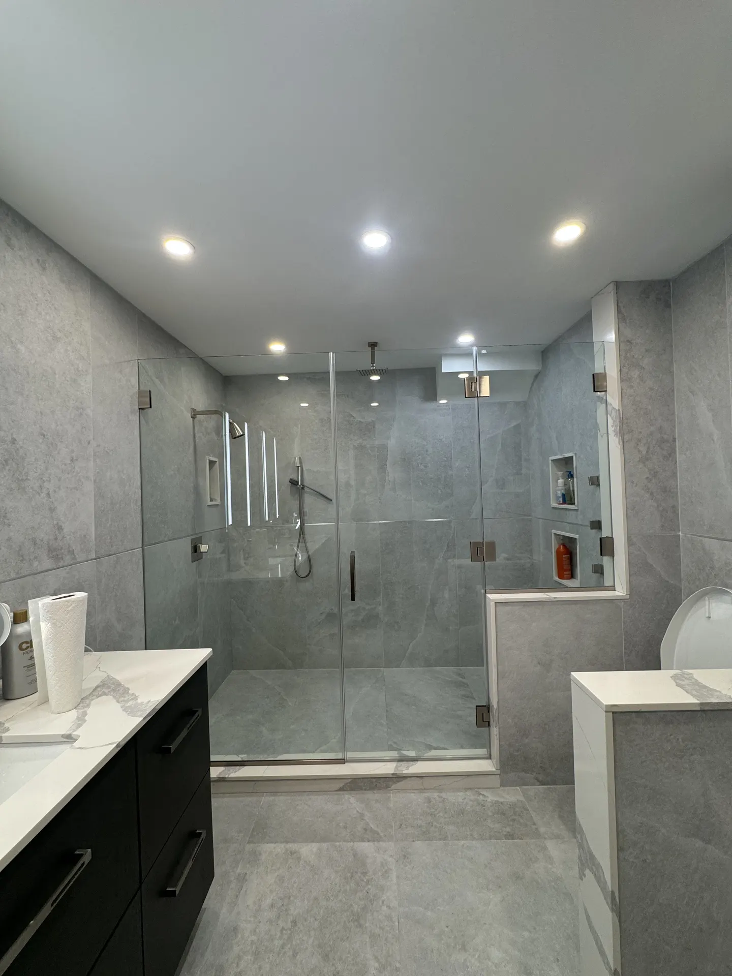 Frameless shower enclosure with a fixed panel and hinged door